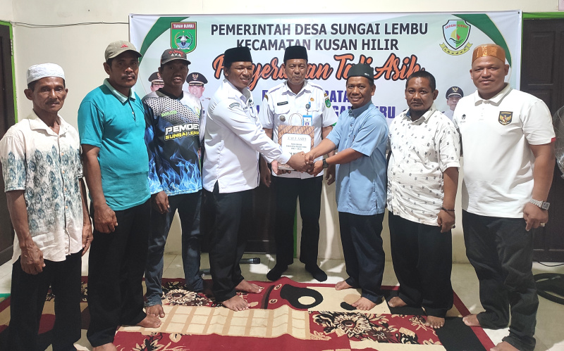 (Foto : Man Hidayat) Kepala Desa Sungai Lembu, H Rusniansyah (kiri) menyerahkan Tali Asih Kepada Kepala Desa Purna Tugas Selama Dua Periode di Saksikan Camat Kusan Hilir, Suparman