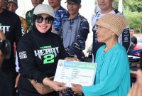 Ketua DPRD Kotabaru, Suwanti Saat Serahkan Kartu Sehat Pada Warga Setempat di Acara Terabas Hebat 2 di Goa Lowo Kotabaru
