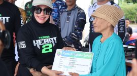 Ketua DPRD Kotabaru, Suwanti Saat Serahkan Kartu Sehat Pada Warga Setempat di Acara Terabas Hebat 2 di Goa Lowo Kotabaru