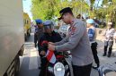 Waka Polres Tanah Bumbu, Kompol Apriyansa SIK Saat Bagikan Bendera pada pengendara di Jalan Raya Batulicin