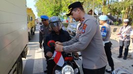 Waka Polres Tanah Bumbu, Kompol Apriyansa SIK Saat Bagikan Bendera pada pengendara di Jalan Raya Batulicin