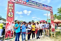 Pemotongan Pita Sebagai Tanda Dimulainya Jalan Sehat Dalam Rangka HUT ke 43 Desa Giri Mulya Kecamatan Kuranji Kabupaten Tanah Bumbu, Minggu (25/1/26).