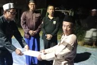 Penyerahan Berkas oleh ketua RT yang  lama kepada ketua RT terpilih (kanan) disaksikan oleh Kades Baharu Utara dan tokoh masyarakat
